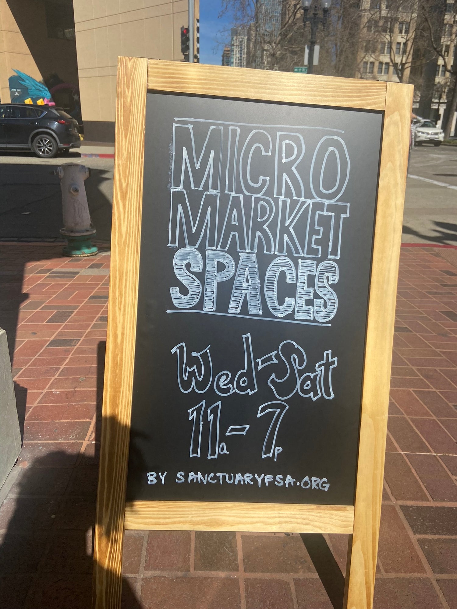 An A fram sign sitting outside of the local shop in the city of Oakland. We're located in Downtown Oakland, near West Oakland, and surrounded by several other local stores