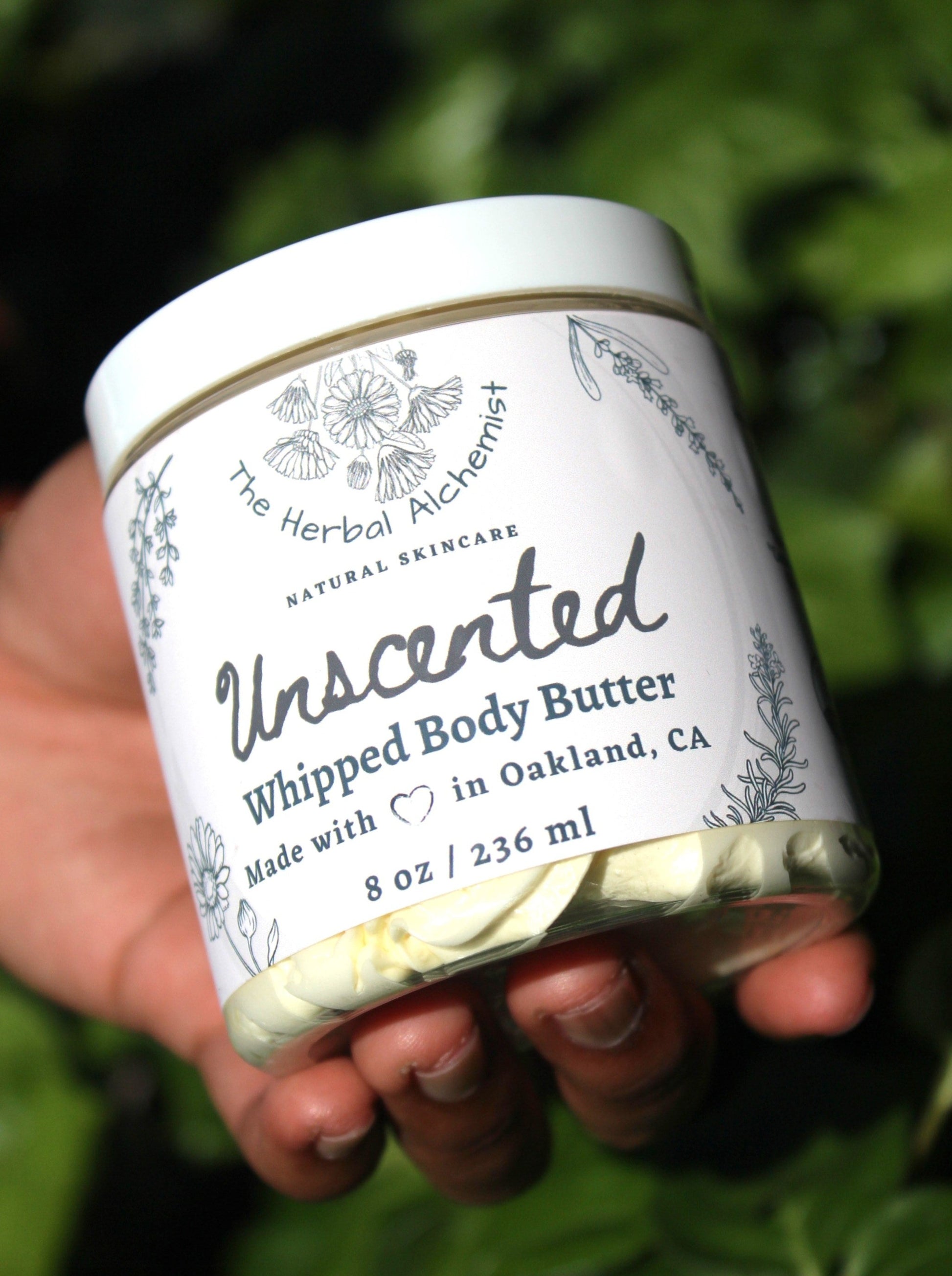 A jar of unscented whipped body butter made with organic raw cocoa butter, unrefined shea butter, organic coconut oil, organic avocado oil, organic apricot kernel oil, organic wheatgerm oil, organic vitamin E, and organic arrowroot powder.